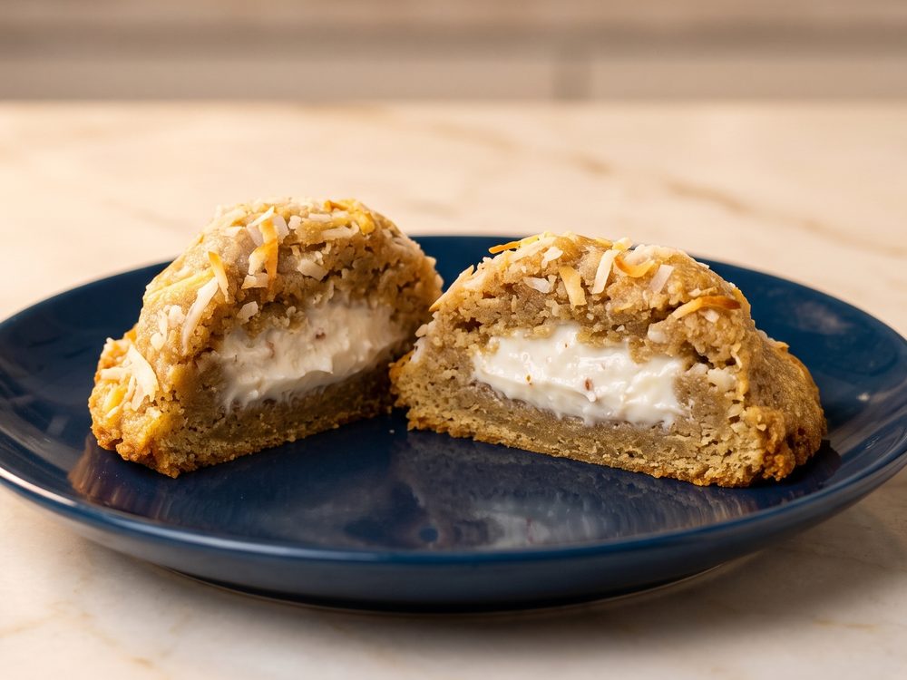Cookie de Mainha Bala Baiana cortado ao meio, com recheio cremoso de coco